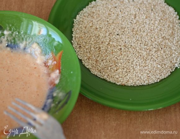 Кунжутные семена всыпать в чашку. Слегка взбить белки. Продолжая взбивать, добавить крахмал, лимонный сок, паприку, соль и перец.