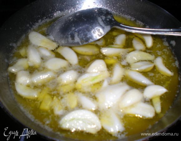 Чеснок очистить и отправить в сковороду с раскаленным маслом. Если зубчики сильно крупные, то нарежте на половинки или четвертинки.