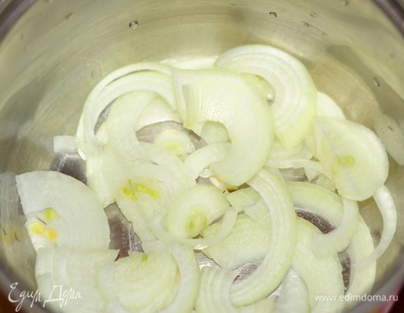 Другую головку лука порезать кольцами и разложить им дно кастрюльки.
