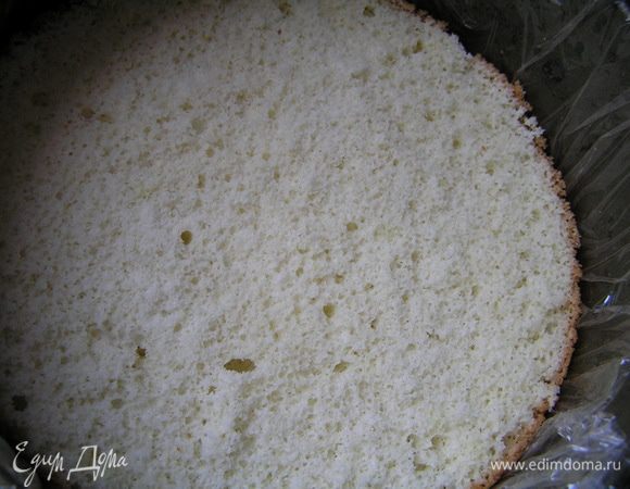 Застелить разъемную форму для торта (диаметр 18-20 см) пищевой пленкой, на дно выложить первый бисквитный корж.
