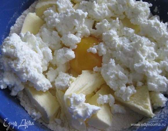Муку просеять, добавить сахарную пудру, лимонную цедру, масло, порезанное на кусочки, творог, желток и замесить тесто. Убрать в холодильник на час.