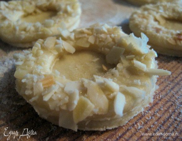 Смазать края белком, слепить две половинки вместе, еще раз смазать белком и посыпать миндалем.