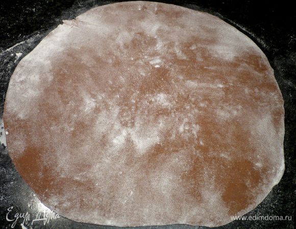 Тесто делим на две равные части. На слегка присыпанной мукой поверхности раскатываем оба пласта теста максимально тонко. Если тесто все еще прилипает к рукам, смажьте ладони растительным маслом, я этого, увы, не сделала, и предпочла маслу муку, в результате чего цвет моих равиоли немного пострадал, а можно добиться более шоколадного густого цвета, если не перебарщивать с мукой.