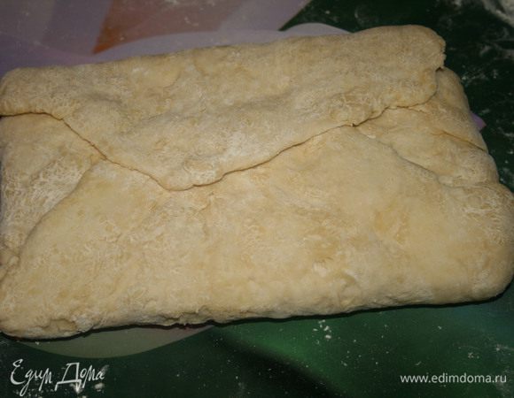 Свернуть тесто конвертиком и перевернуть его швами вниз. Слегка отбить его скалкой, чтобы масло равномерно распределилось по тесту.