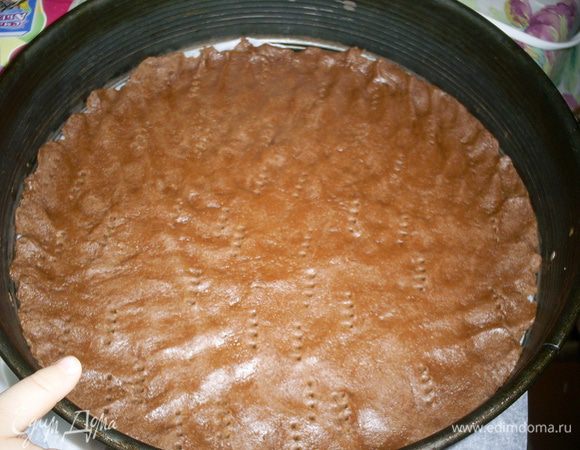 В форму диаметром 24-26 см, выстеленную бумагой выкладываем 2/3 теста, распределяем равномерно по дну. Я делаю это просто рукой и накалываем вилкой. Оставшееся тесто помещаем в морозилку. Чтоб оно быстрее застыло я распределяю его небольшим слоем по пищевой пленке.