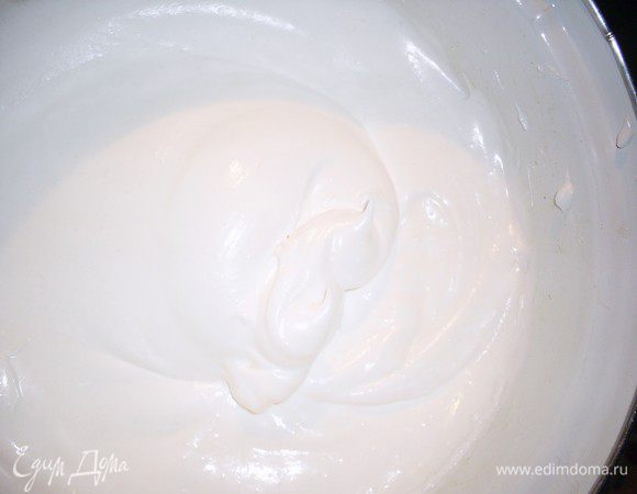 Тем временем займемся безе. Охлажденные белки взбиваем до тех пор, пока они не будут выпадать из кастрюльки при ее переворачивании. Затем, не прекращая взбивания, добавляем сахар минимум за 10 приемов. Взбиваем до получения гладкой массы, которая слегка тянется за венчиками и не выпадает из кастрюльки при ее переворачивании.