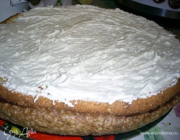 На безе с шоколадной прослойкой кладем первый корж и смазываем половиной крема.