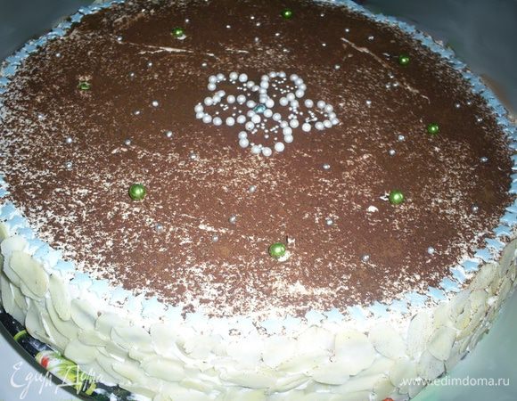 Верх торта посыпаем какао через ситечко. Автор рекомендует украшать готовое изделие шоколадными спиральками, но ни времени, ни желания их делать у меня не было. Бока торта я украсила миндальными лепестками, а верх кондитерской посыпкой и съедобными бусинками. Дать настояться несколько часов в холодильнике и приятного аппетита!