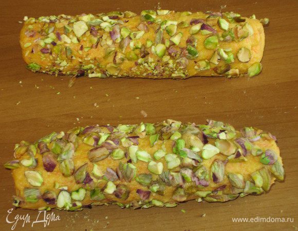 Сформировать 2 колбаски диаметром 3 см. Высыпаем на рабочую поверхность измельчённые фисташки, обваливаем со всех сторон, заворачиваем в плёнку и отправляем в холодильник на 1 час.