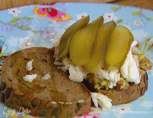 Хлеб сбрызнуть оливковым маслом, на один кусок намазать заправку из авокадо, сверху выложить крабовое мясо, затем соленый огурец, целые листья салата и накрыть вторым куском хлеба.