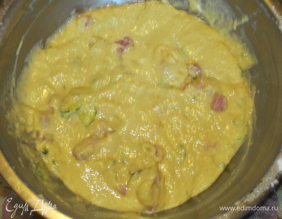 Просеять муку с разрыхлителем и ввести в яично-молочную массу. Добавить Пармезан,бекон, цукини и тщательно перемешать.