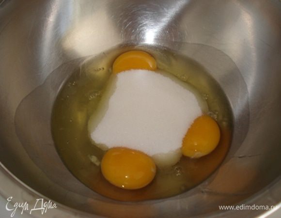 Духовку разогреть до 180°. В прямоугольную форму для кекса положить пергамент. Яйца с сахаром взбить до бела.
