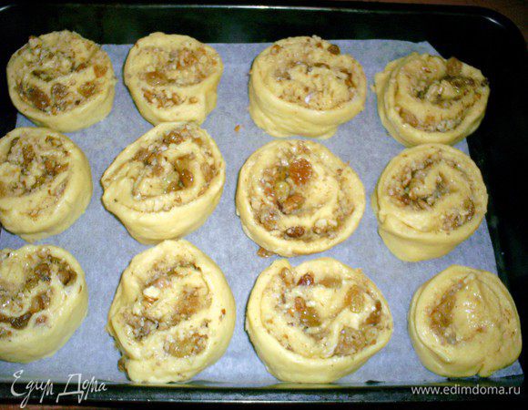 Готовый рулет нарезаем на порционные кусочки толщиной примерно 5 см и выкладываем на противень, застеленный бумагой, срезом к бумаге. 