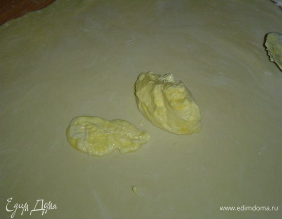 каждую часть раскатываем. Мягкое сливочное масло делим на две равные части и смазываем два раскатанных пласта.