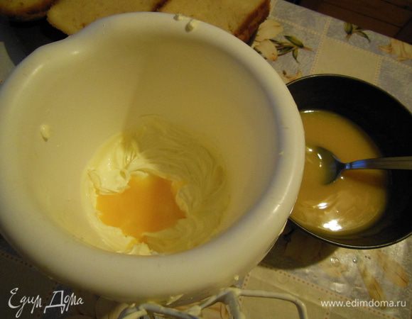 Когда наша желтково-сахарная смесь остыла, добавлять ее по столовой ложке к ванильному маслу. Взбивать каждый раз. В конце добавить коньяк.