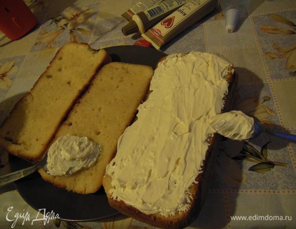 Промазать белым кремом разрезанные бисквиты. 