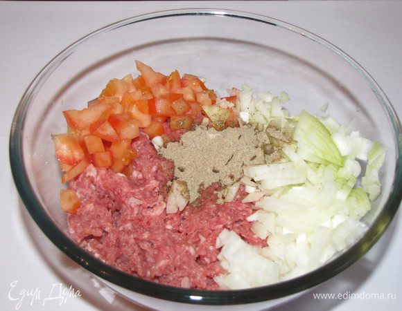 Мелко нарезать лук и помидор. Смешать бараний фарш с луком, помидорами и специями, тательно перемешать.