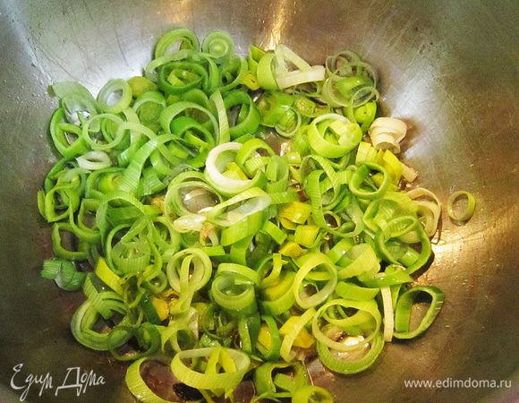 Положить в сотейник с "чесночным" маслом порезанный лук-порей. Немного обжарить в течение 2 мин.