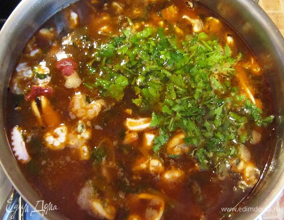 Влить рыбный бульон. Довести до кипения. Добавить порезанную петрушку. 