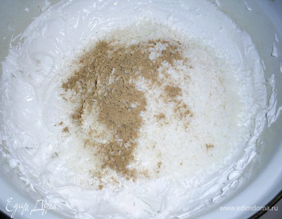 Снимаем массу с бани, всыпаем сразу всю кокосовую стружку и корицу и спокойно перемешиваем ложкой, собирая все брызги со стенок.