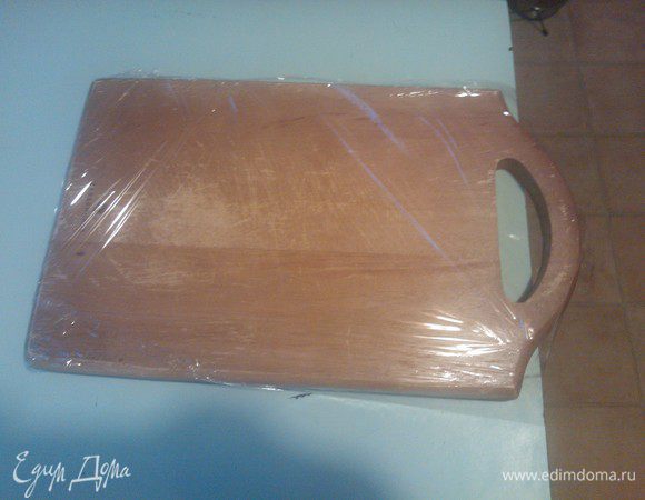 Пока займемся поверхностью. Для этого возьмем разделочную доску и обернем ее с одной стороны пищевой пленкой так, чтобы можно было ее легко снять. Т. е. просто загнем несколько сантиметров пленки на вторую сторону доски.