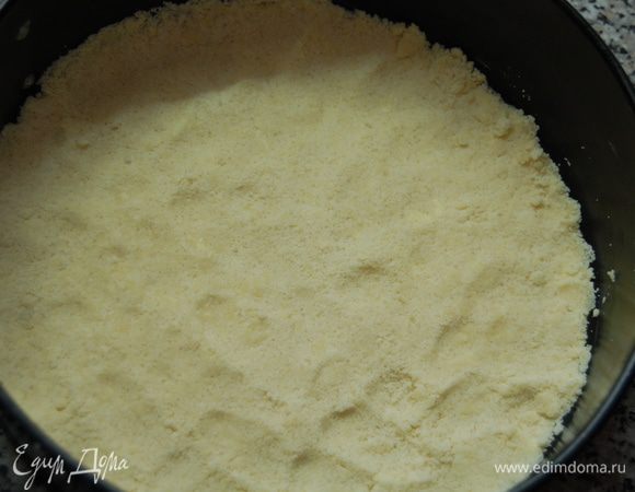 Половину крошек выложить в форму и слегка прижать ко дну.