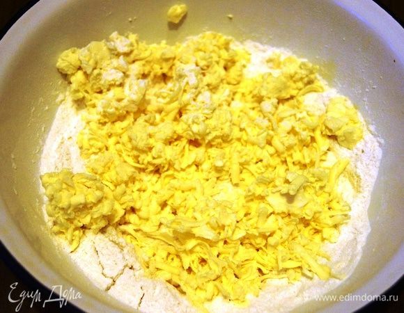 В чашку насыпаем муку, сахар и натираем на крупной терке сливочное масло, соединяем 