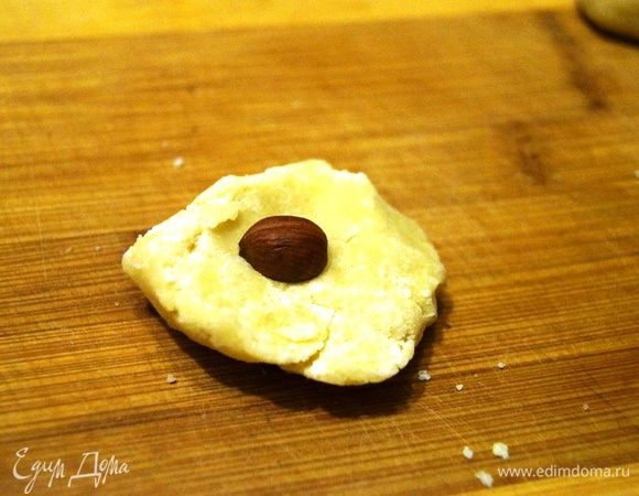 Отщипываем небольшой кусочек теста, в серединку ложим орешек