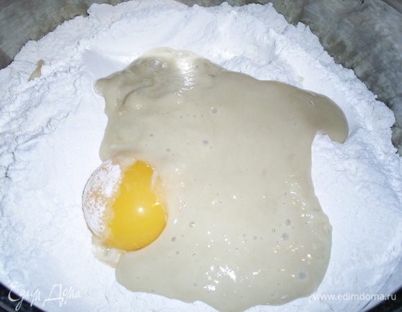 Когда опара подойдет, добавляем ее в емкость с мукой (400 г), туда же отправляем желтки. 