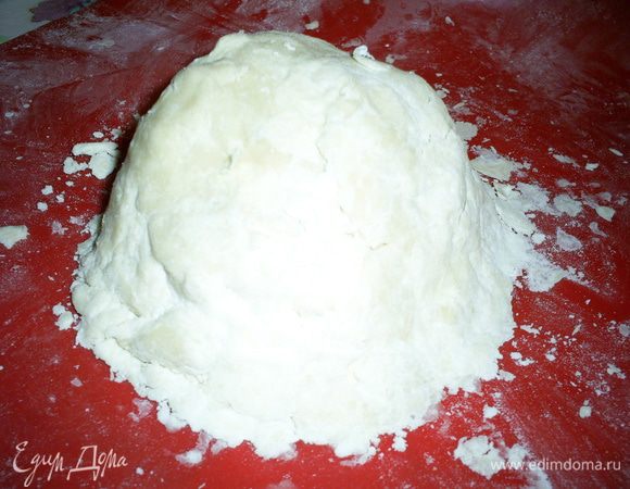 Тем временем холодный маргарин порубим ножом с оставшейся мукой (100 г). Руками слепим крошку в комок.