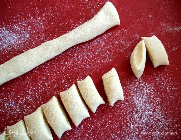   Подсыпать на рабочую поверхность муки для удобства работы. Скатать из полученного теста колбаски диаметром около 2 см и разрезать их на кусочки по 1,5 см. 