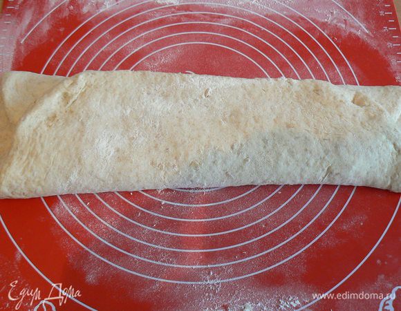 После часа расстойки,тесто выложить на подсыпанный мукой стол и растянуть его в четырёхугольник. Теперь берём одну сторону и потягивая загибаем её к середине. Так же поступить с другой стороной .