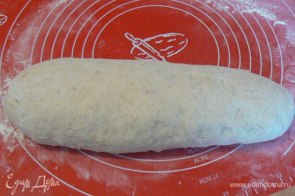 Потом придать хлебу овальную форму, смазать молоком и посыпать овсяными хлопьями. Накрыть плёнкой и поставить на расстойку еще на 30-40мин.