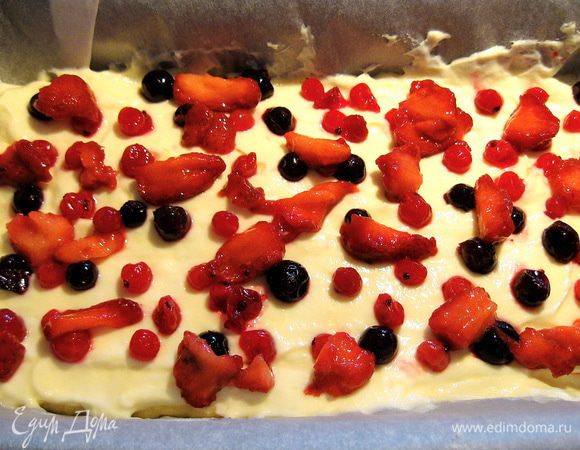 Выкладываем половину получившейся массы на тесто. Сверху выкладываем ягоды.