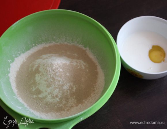 В одной большой миске смешайте просеянную муку,сах. пудру и дрожжи.В другой мисочке смешайте молоко и яйцо.