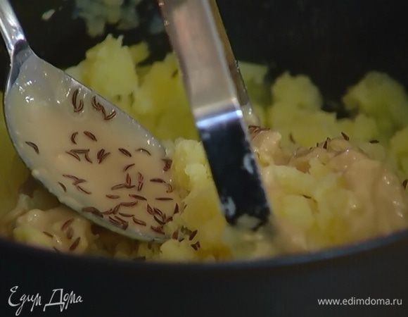 К картофелю добавить йогурт, пасту тахини, тмин, посолить, поперчить и размять толкушкой.