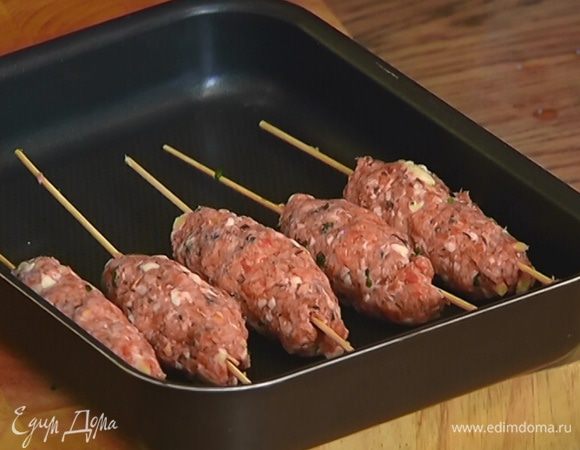 Сформировать на деревянных шпажках плотные колбаски из фарша и выложить их в небольшой глубокий противень.