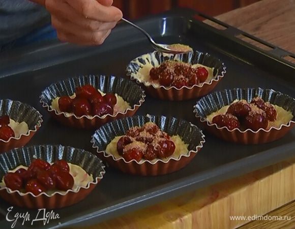 Охлажденное тесто распределить по формочкам для тарталеток, в центр выложить по нескольку ягод вишни и посыпать сахаром.