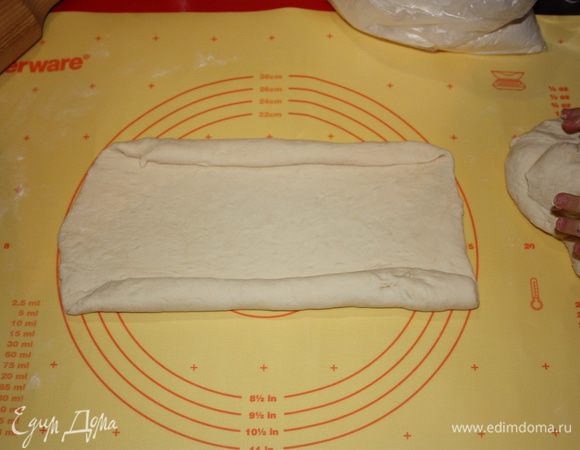 Теперь есть два варианта. Либо выложить начинку и с ней сворачивать,либо без нее. Как вам нравится. в общем,с двух сторон начинаем скатывать тесто трубочкой.