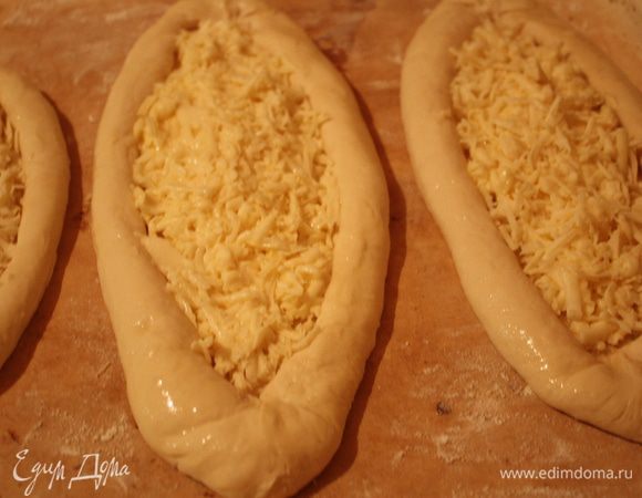 Теперь начинка. на один средний хачапури у меня идет: 150-170 г сулугуни,1 яйцо.Сыр натираем на терке,смешиваем с яйцом и выкладываем в нашу заготовку.Количество яиц умножьте на кол-во порций и в одной миске смешайте всю начинку.Смазываем взбитым яйцом края и оставляем постоять минут 10-15,после этого убираем в разогретую духовку. На 12-15 минут,мне хватает 12))