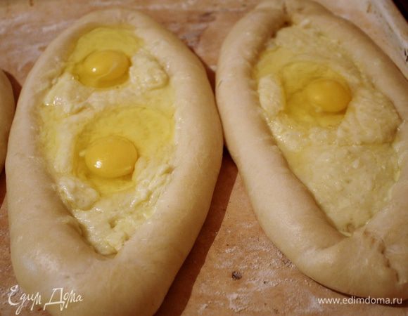 Достаем и выливаем в каждый хачапури по яичку,а то и по два (у меня же они большие).Удобней сначала яйцо вылить в небольшую кружечку,а уже из нее вылить на хачапури,предварительно "расчистив" место под него ножичком или вилкой.