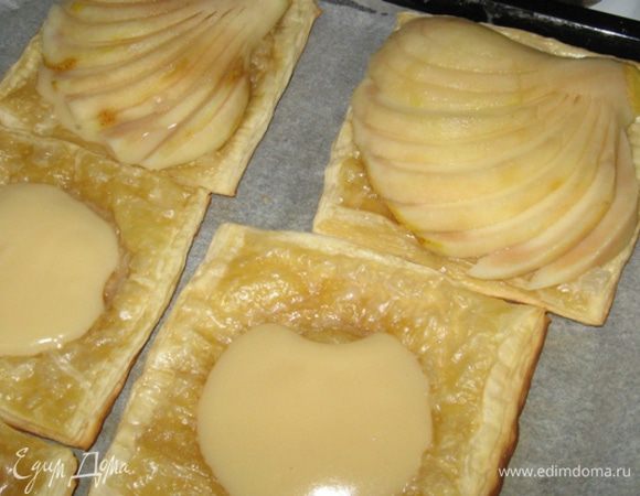 Дальше - ювелирная работа: аккуратно, под углом наискосок, делаем на груше тонкие надрезы, разрезая ее как бы веером или лепестками. На основание выкладываем ложку крема, сверху на эту подушку переносим с помощью широкого ножа грушу и раскрываем веером нижнюю часть. Доводим 10 минут в духовке и подаем к столу. Приятного аппетита.