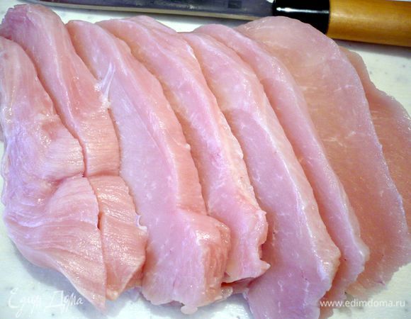 Нарезаем филе грудки на шнитцели, затем укладываем их на доску, накрываем пленкой и отбиваем молотком, я использовала ровную сторону молотка, нерифленую, и отбивала только с одной стороны. Солим и перчим индейку, накрываем пленкой и убираем в холодильник.