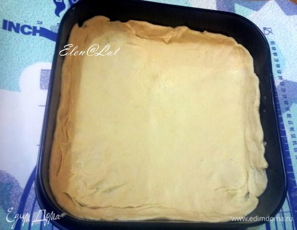 Большую часть теста раскатайте и переложите в форму, застеленную пергаментом, сделайте бортики.
