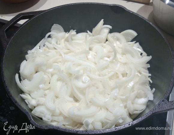 Когда мясо обжарилось, добавляем часть лука (нарезанный полукольцами)...