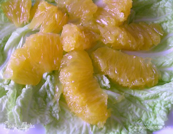 Листья салата разложить по тарелкам, добавить очищенные от пленок дольки апельсина,