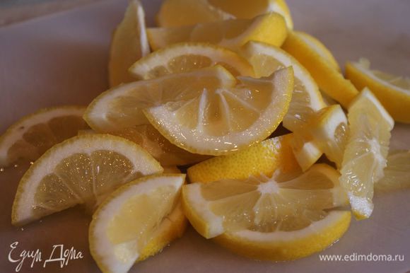 Лимон тщательно помойте и нарежьте на кусочки. Удалите косточки.