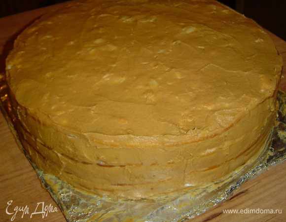 Взбиваем размягченное сливочное масло, к нему частями добавляем сгущенное молоко и взбиваем до образования пышной массы. Этим кремом смазываем верх и бока торта, а затем отправляем торт в холодильник на 5-6 часов.