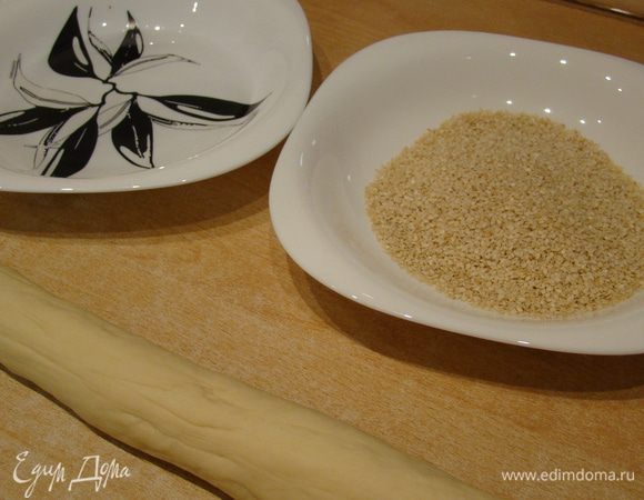 Подготовить воду и кунжут. Тесто разделить на 14 частей, руками сформировать толстые колбаски