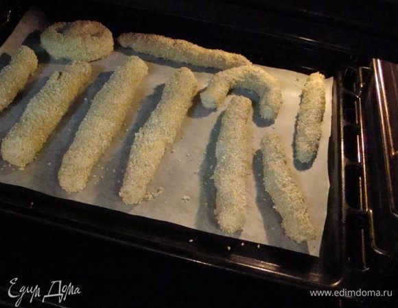 Каждую обмакнуть в воду, затем в кунжут и отправить на противень. Из нескольких палочек я скрутила толстые бублики-крендельки и хорошенько обмакнула их в сахаре